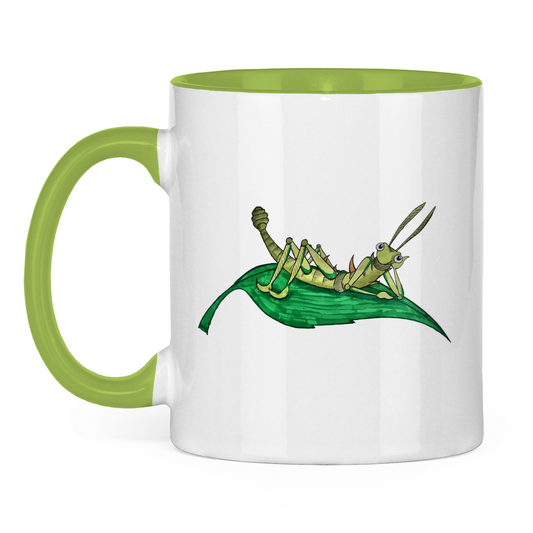 Tasse zweifarbig Krabbelcrew Dornschrecke Kasimir liegt auf einem Blatt