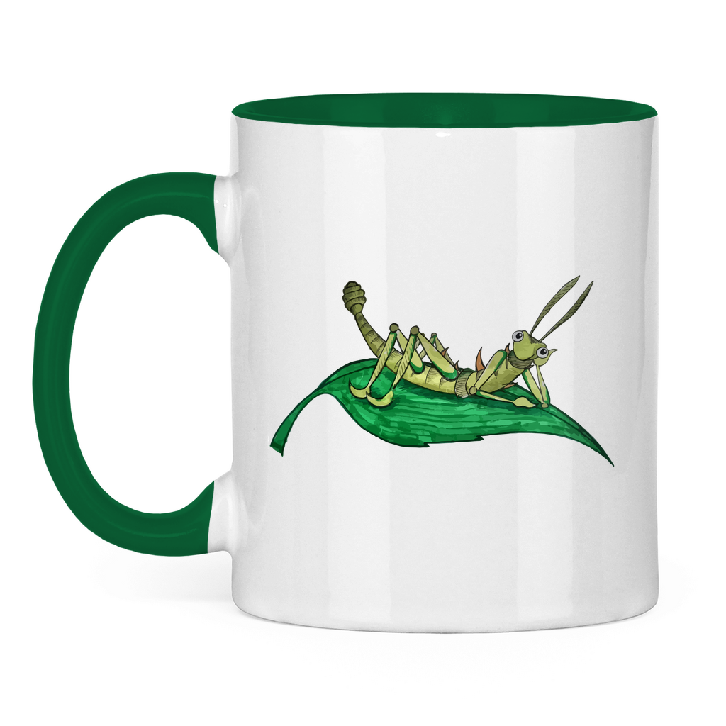 Tasse zweifarbig Krabbelcrew Dornschrecke Kasimir liegt auf einem Blatt