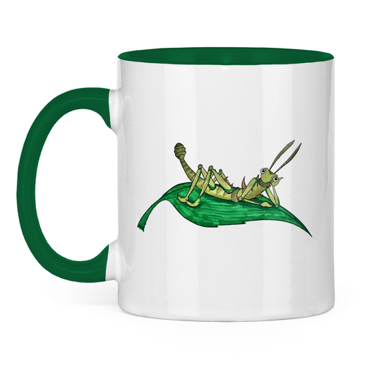 Tasse zweifarbig Krabbelcrew Dornschrecke Kasimir liegt auf einem Blatt